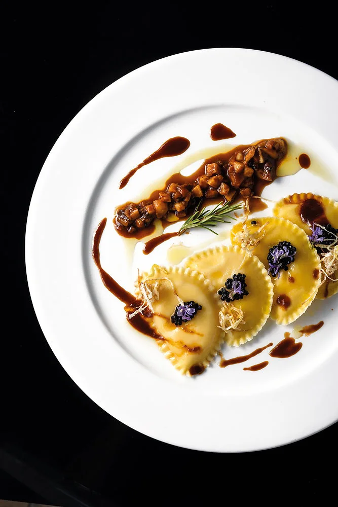 Raviolotti con polenta e “Montasio DOP”, funghi cardoncelli, demi glace vegana, sferificazione di tartufo e po