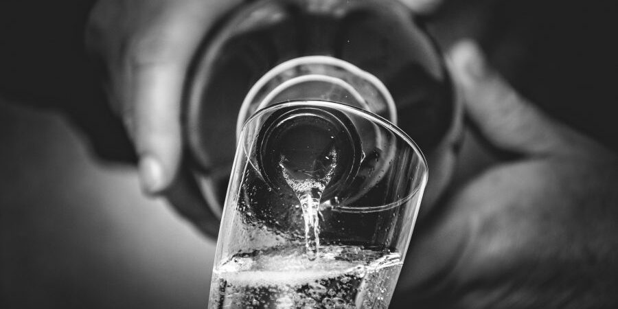 Spumanti, persona che versa spumante in un calice Spumanti, persona che versa spumante in un calice