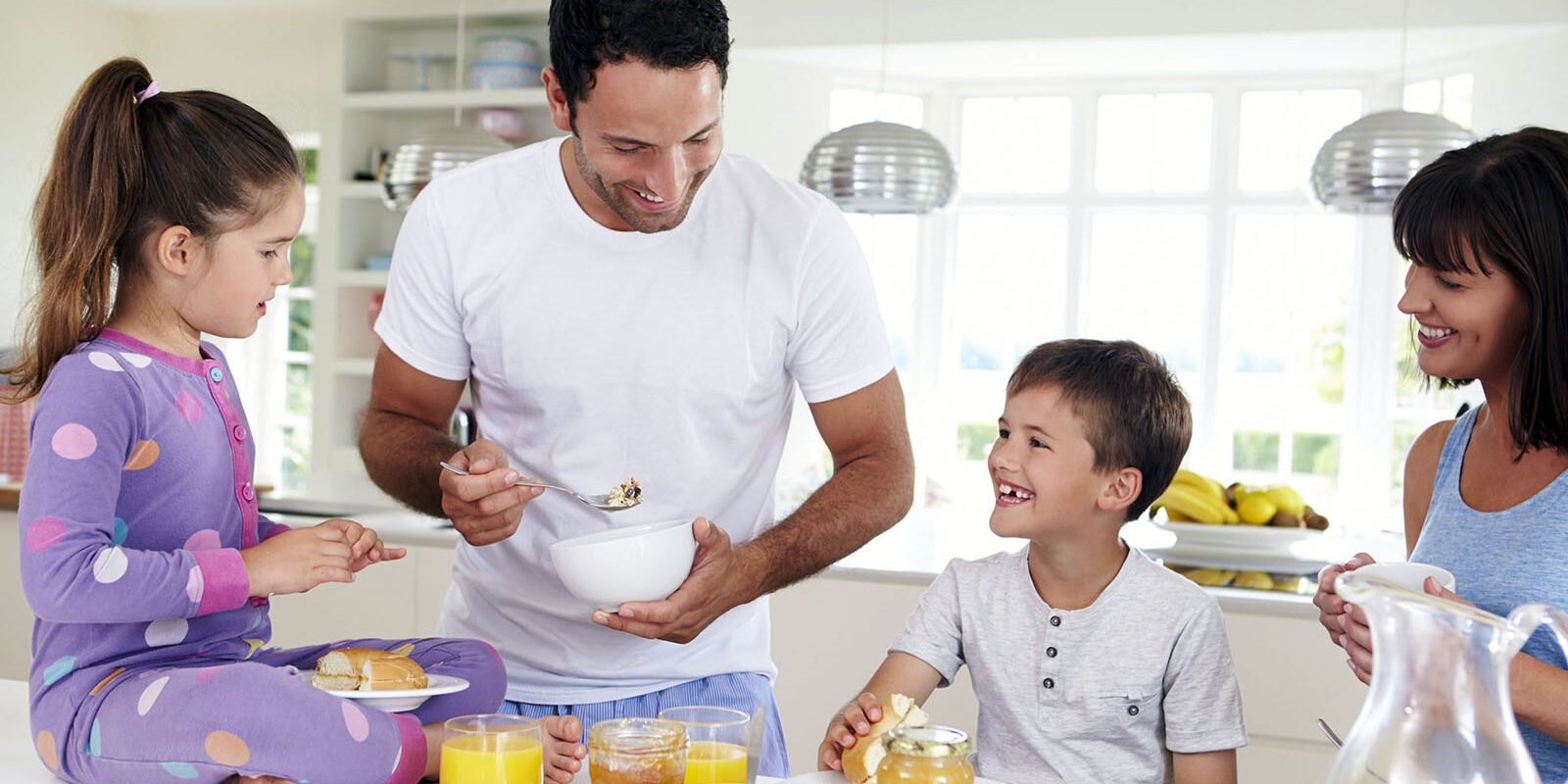 Family Eating Breakfast In Kitchen Together