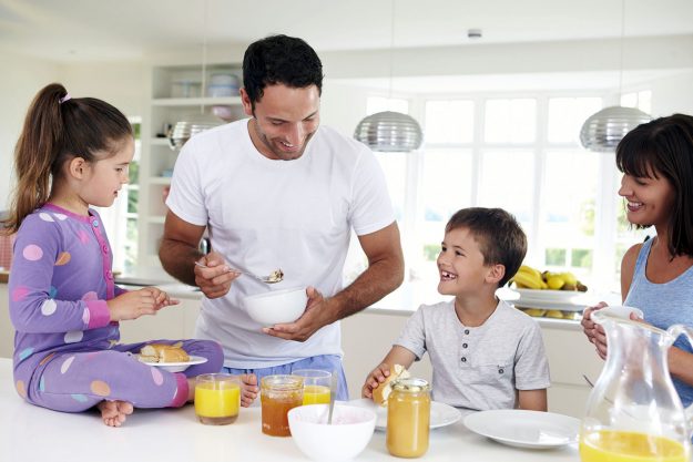 Family Eating Breakfast In Kitchen Together