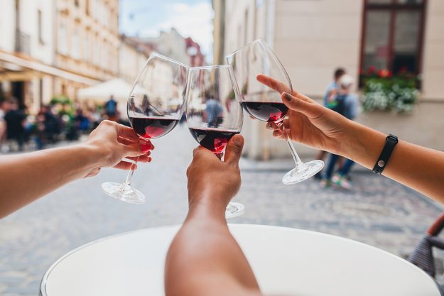 Come bevono le nuove generazioni? Come bevono le nuove generazioni? Un articolo di Alessandro Rossi. In foto, tre braccia avvicinano i calici con vino rosso in un brindisi