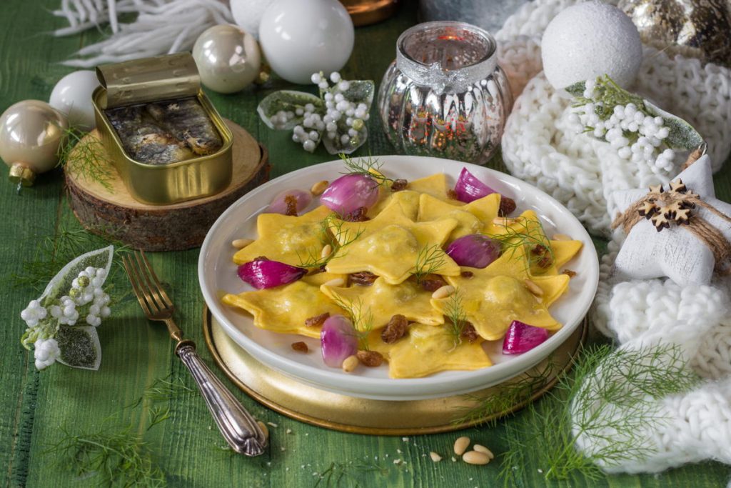 Ravioli di natale a stella con sardine, pinoli, cipolla stufata e uvetta, conditi con burro all’arancia