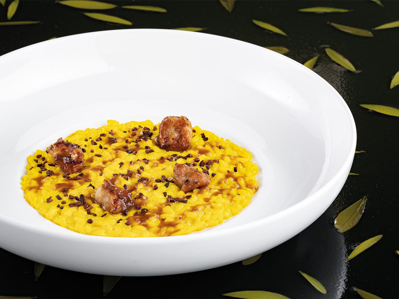 Risotto allo zafferano con animelle di agnello caramellate e grue di cacao