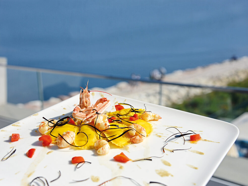 Raviolotti al baccalà con code di scampi dell’Adriatico, datterino scottato e crema di melanzana