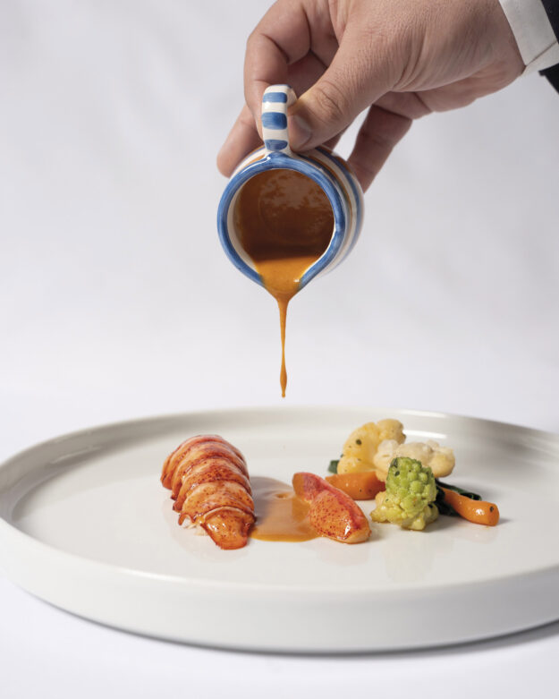Astice con composé di verdurine baby stagionali, salsa royale e raviolo di foie gras