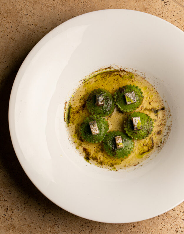 Tortelli di pasta all’uovo con ripieno di patate, alici, uva passa e pinoli