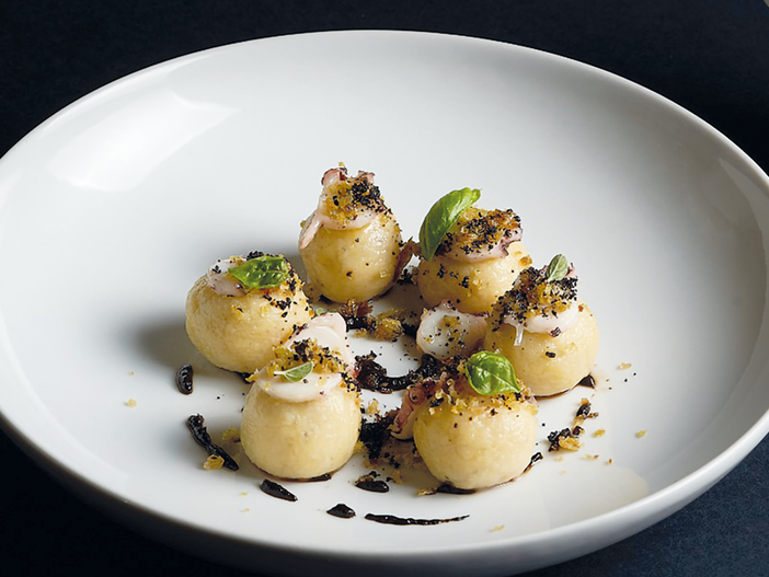 I gnocchi di patate, polpo, piselli e aglio nero