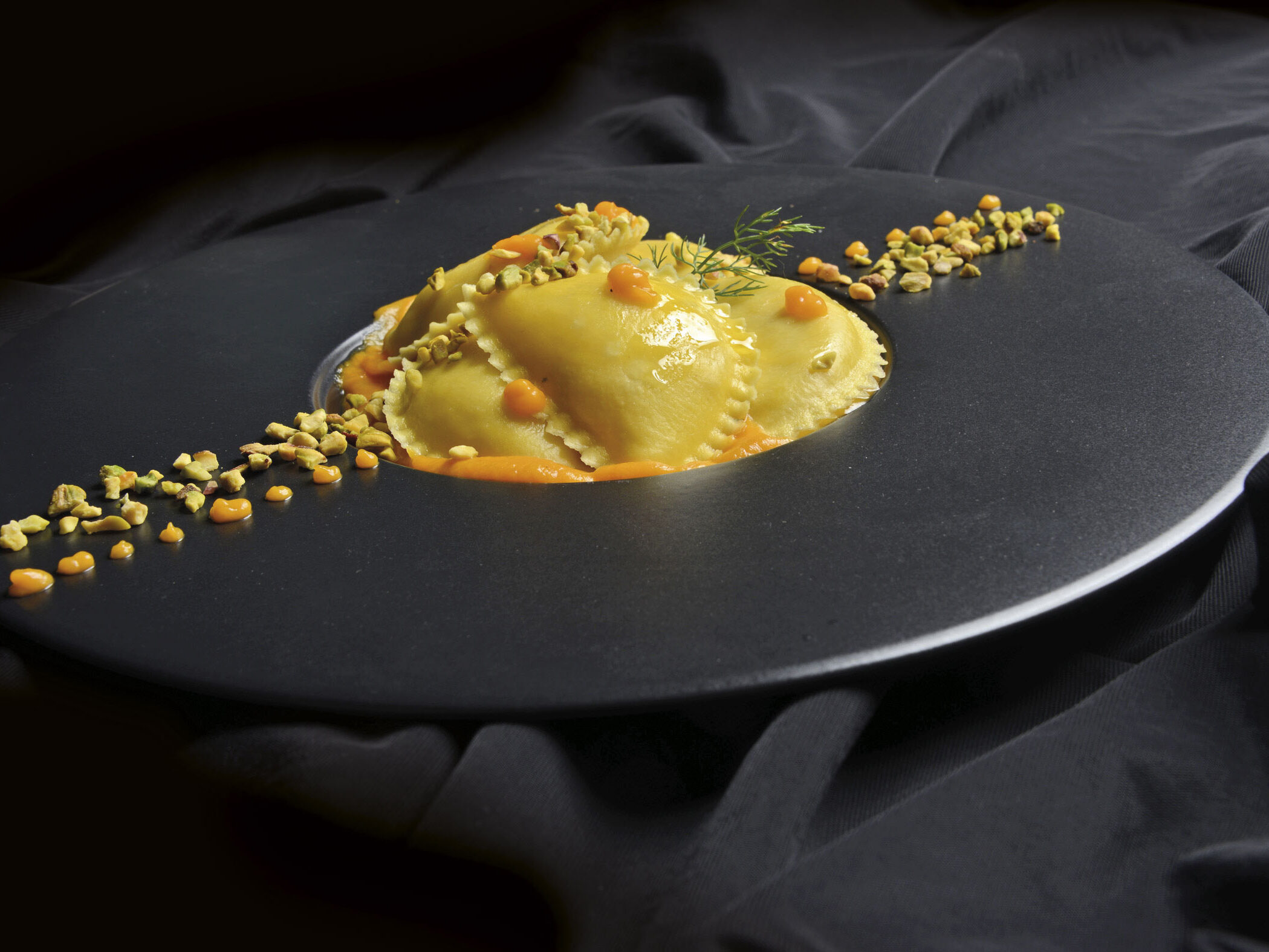 Raviolotti al baccalà con crema di zucca, nocciole del Piemonte e pistacchi di Bronte