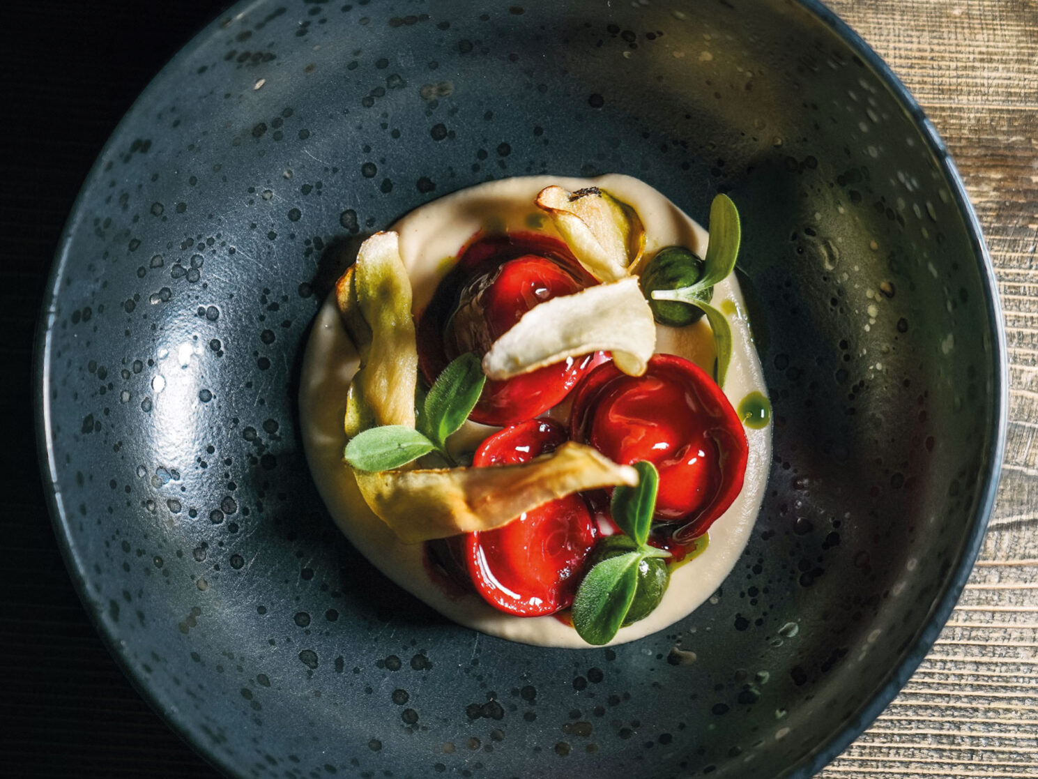 Ravioli di barbabietola rossa con cuore di formaggio, serviti con chips di radice di prezzemolo
